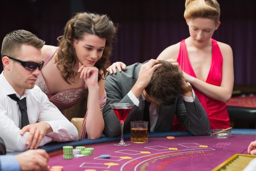 Woman comforting man losing at poker