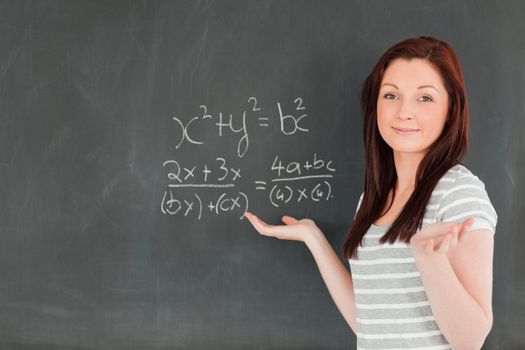 Smiling young woman solving an equation