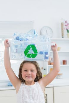 Girl holding crate with plastics on her head