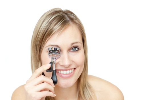 Smiling woman using an eyelash curler 