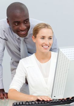 Ethnic businessman and his colleague working at a computer in the office