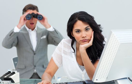 Brunette businesswoman annoyed by a man looking through binocula