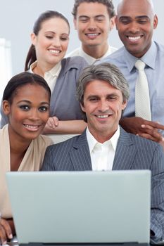 A business group showing ethnic diversity working at a laptop 