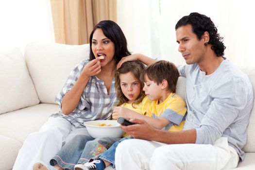 Lively family watching TV on sofa