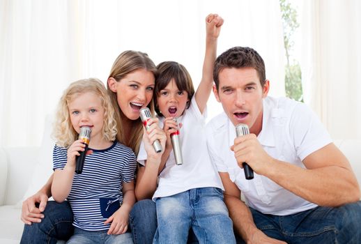 Portrait of a lively family singing through microphone