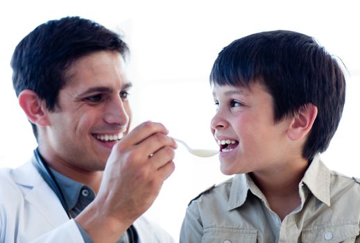 Self-assured doctor giving medicine to a little boy against a white background