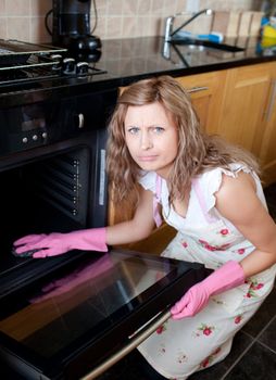 Annoyed woman cleaning the oven
