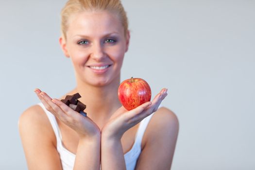 Attractive woman showing chocolate and apple focus on chocolate and apple 