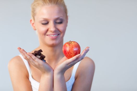 Beautiful woman showing chocolate and apple focus on chocolate and apple 