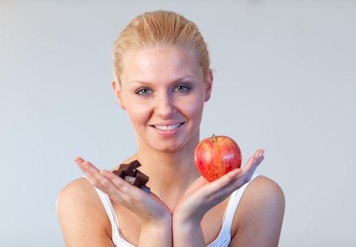 Friendly woman holding chocolate and apple focus on woman 