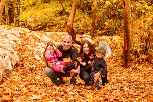Young family in autumnal forest
