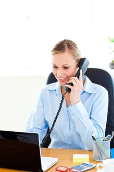 Ambitious businesswoman talking on phone using her laptop