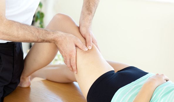 Caucasian young physical therapist giving a leg massage