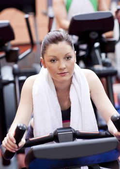 Serious athletic woman pedaling during a training in a sport cen
