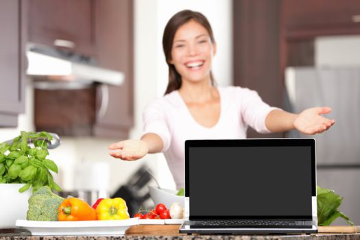 Woman cooking showing laptop in kitchen