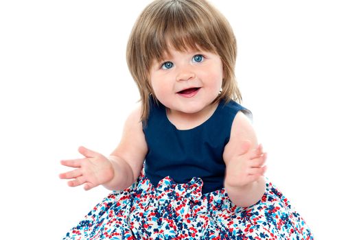 Chubby little toddler wearing dotted blue frock