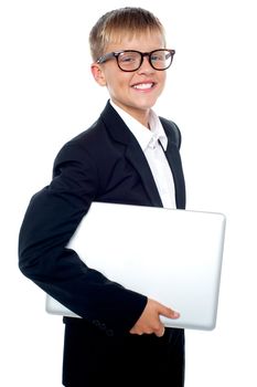 Bespectacled young boy carrying a laptop