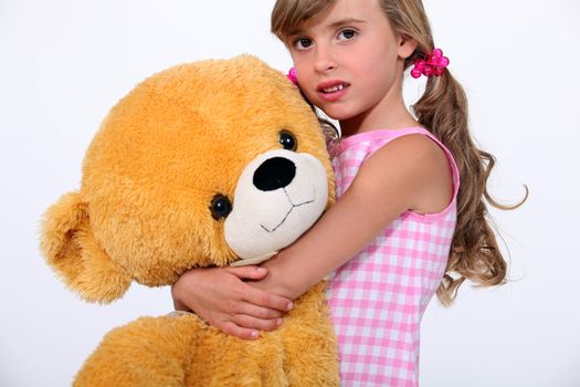Little girl holding giant teddy bear