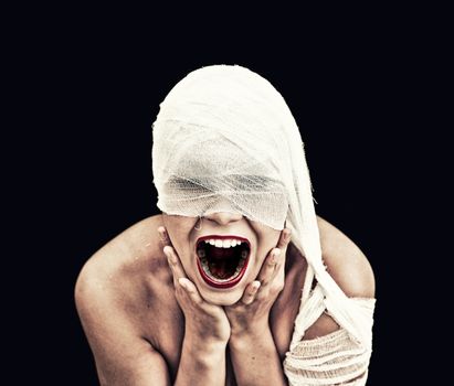 screaming woman  in bandage over black background (gothic style concept) 