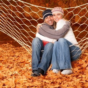 Young family hugging in hammock