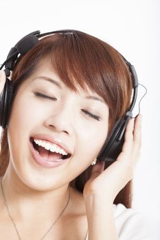 asian woman listening and enjoying music in headphones