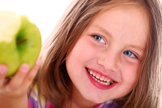 Little girl eating green apple