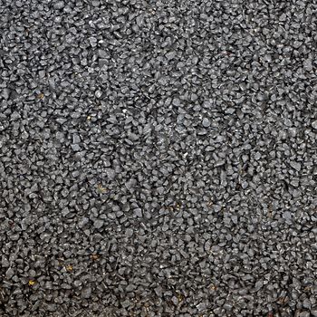 Closeup of the black tar surface of an asphalt road