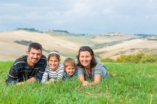 Happy family having fun outdoors in Tuscan