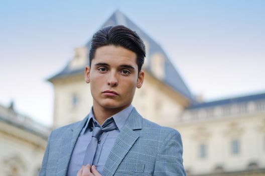 Portrait of handsome young male model on river banks looking in camera