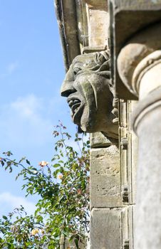 Old gargoyle with ugly open mouth