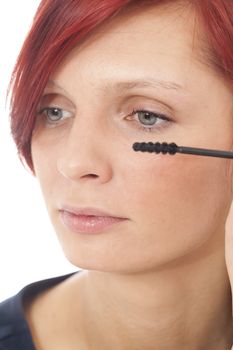 Women applying black mascara on the eyelashes