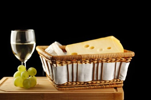 White wine in fine glass with cheese and grape