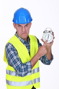 Angry builder pointing at alarm clock