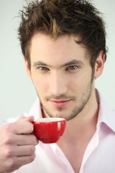 Man holding small cup of coffee