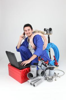 Labourer surrounded by tools and equipment