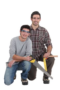 Carpenter and apprentice kneeling