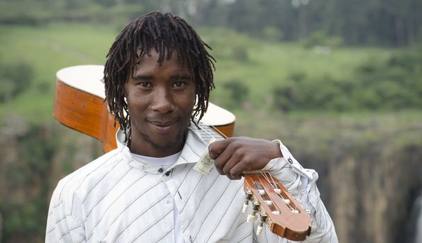 African busker with guitar on shoulder and ten rand note