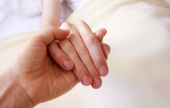 Holding the hand of sick loved one