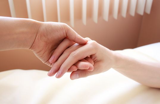 Holding hand of a sick loved one