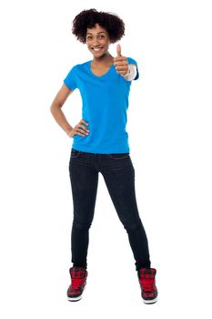 Stylish young model on white background gesturing thumbs up.