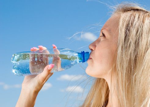 Beautiful blond girl drinking water