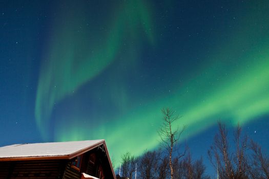 Northern Lights (Aurora Borealis) above a cabin