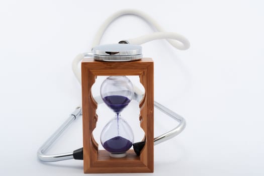 Using stethoscope with hourglass on white background
