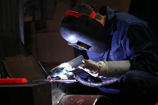 welders with protective mask in the factory