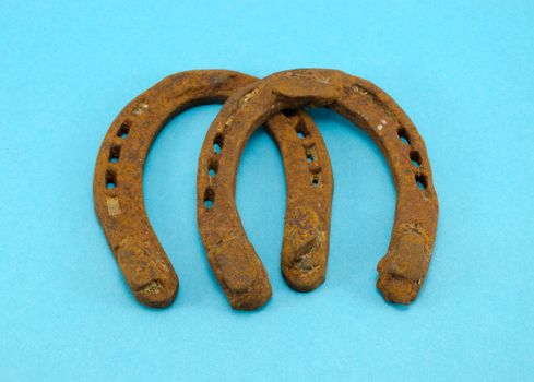 retro rusty pair of horseshoes on blue background 