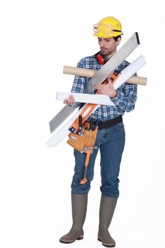 young handsome carpenter carrying miscellaneous tools