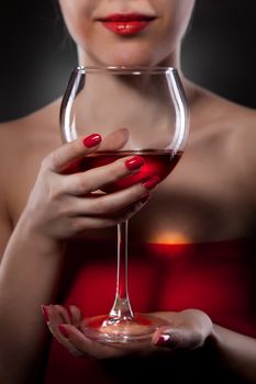 woman in red holding wine glass and smiles