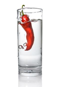 red pepper dropped into water glass with bubbles