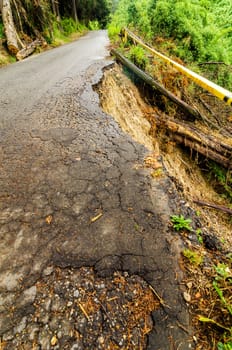 A dangerous damaged road that has fallen down the hillside