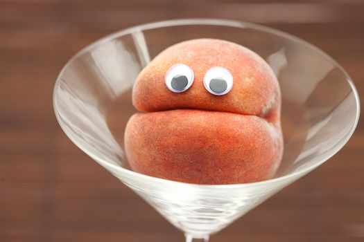 Peach with eyes in the glass martini on a bamboo mat